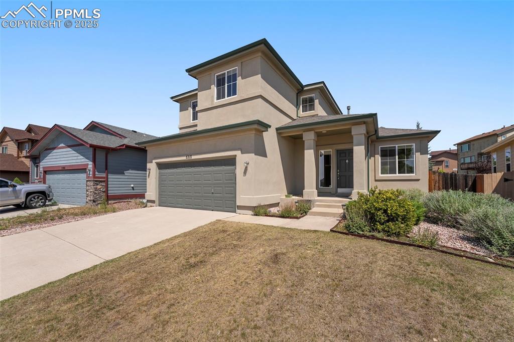a front view of a house with a yard and garage