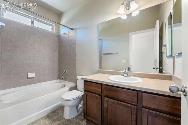 a bathroom with a granite countertop sink toilet a large mirror a bathtub and shower