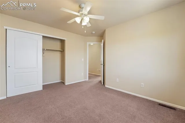 an empty room with a ceiling fan and a bathroom