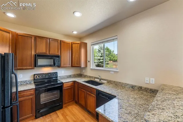 a kitchen with granite countertop a stove sink and microwave