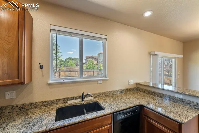a kitchen with granite countertop a sink and a window