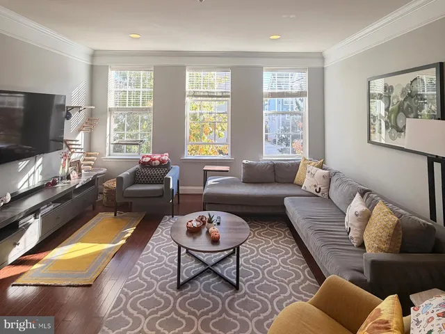 a living room with furniture a flat screen tv and a large window