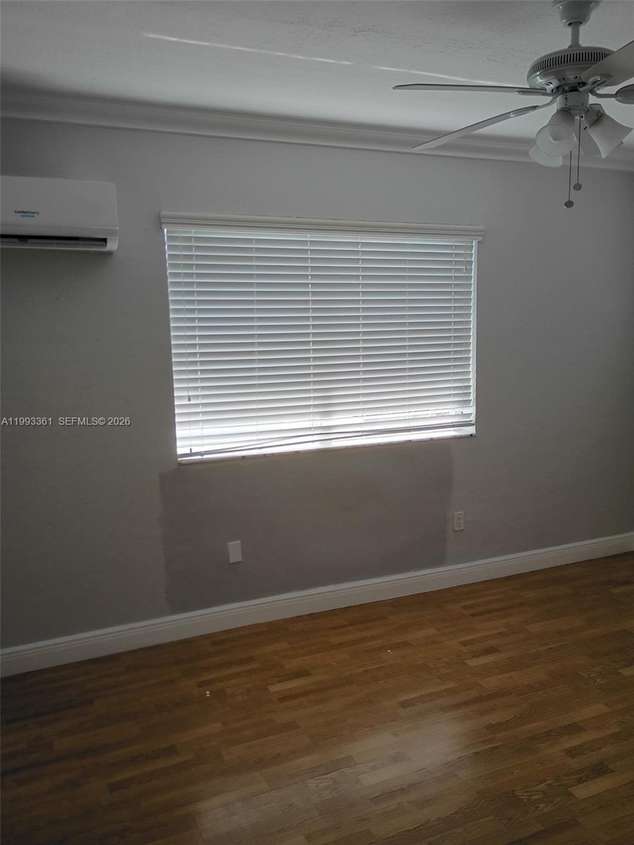 755 83rd Street, Unit 3 Miami Beach, FL 33141 - Photo 19 of 24 a view of an empty room with wooden floor and a window