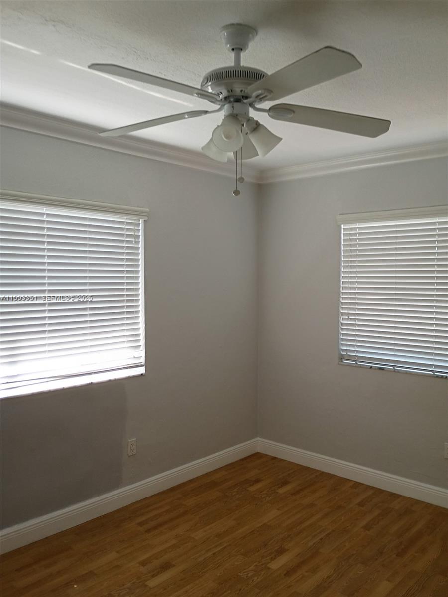 755 83rd Street, Unit 3 Miami Beach, FL 33141 - Photo 20 of 24 a view of an empty room with wooden floor and a window