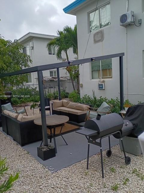 755 83rd Street, Unit 3 Miami Beach, FL 33141 - Photo 8 of 24 a view of a patio with couches table and chairs under an umbrella