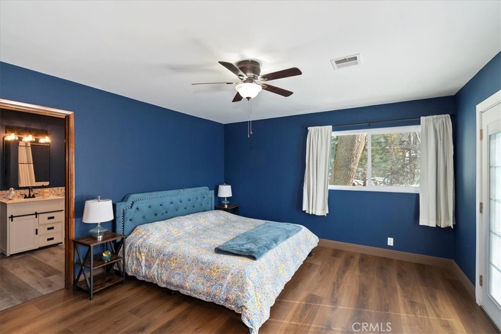 27814 North Bay Road Lake Arrowhead, CA 92352 - Photo 37 of 68 a bedroom with a large bed and a chandelier