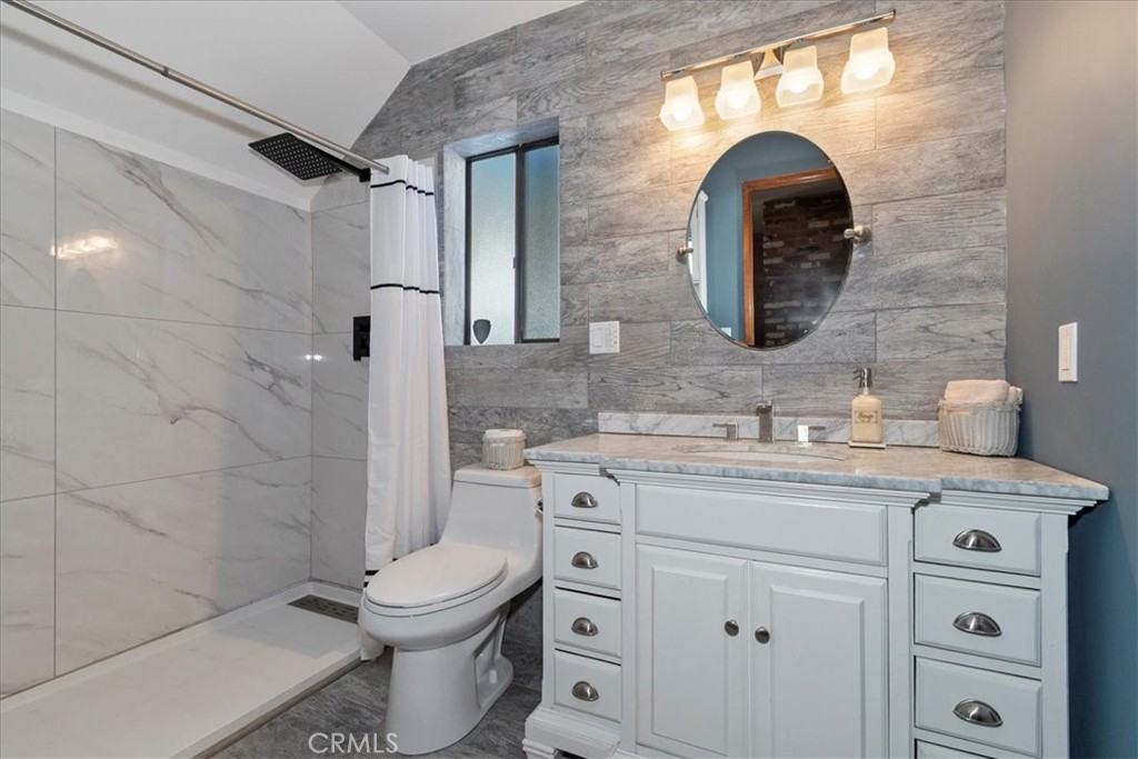 27814 North Bay Road Lake Arrowhead, CA 92352 - Photo 51 of 68 a bathroom with a granite countertop toilet sink and mirror