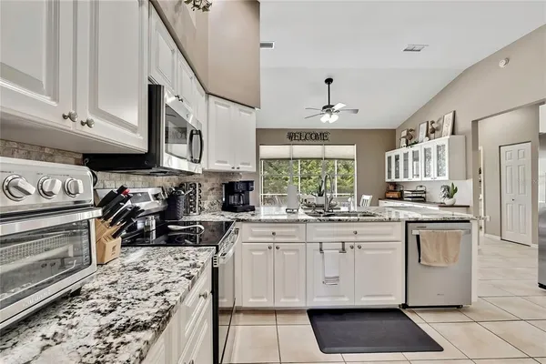 a kitchen with white cabinets sink and stainless steel appliances