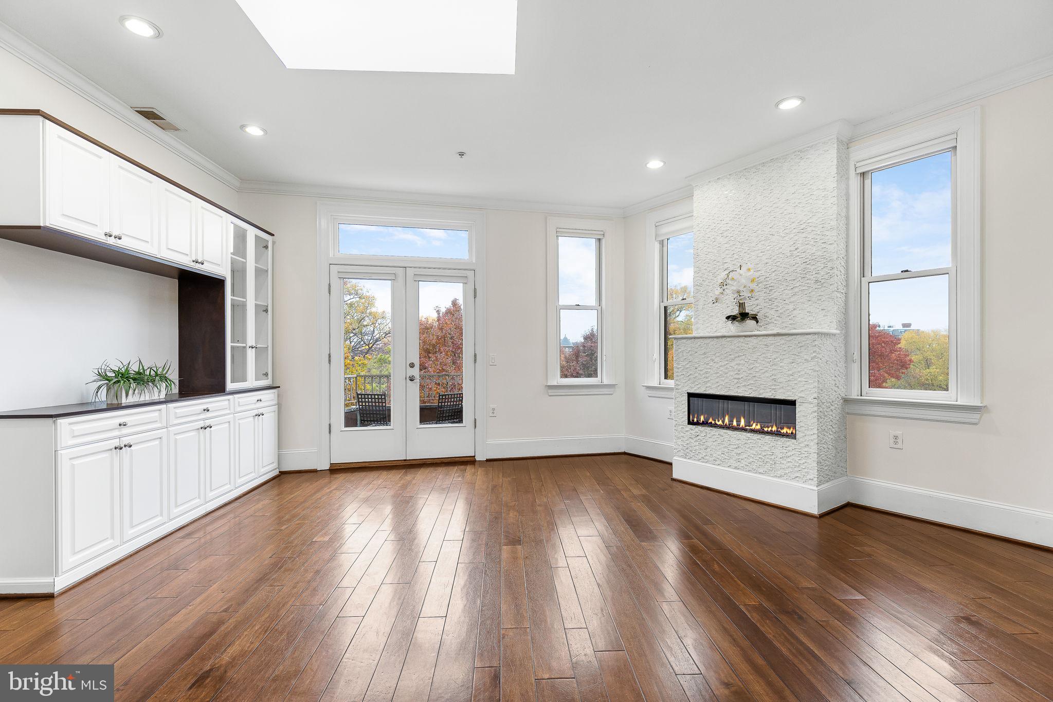 20 Logan Circle Northwest, Unit 33 Washington, DC 20005 - Photo 10 of 32 a large kitchen with stainless steel appliances granite countertop a large window a oven and white cabinets with wooden floors