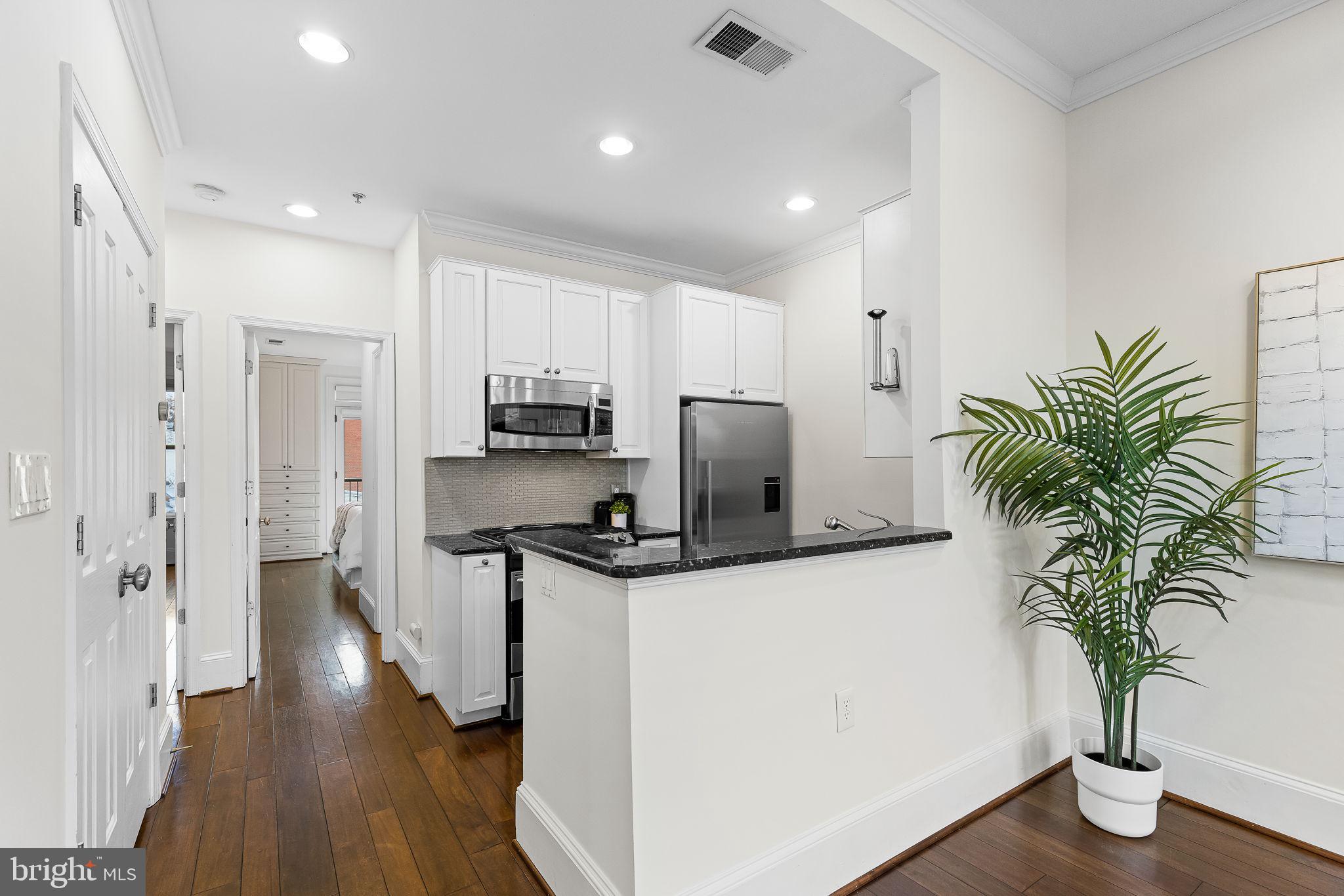 20 Logan Circle Northwest, Unit 33 Washington, DC 20005 - Photo 14 of 32 a kitchen with stainless steel appliances a refrigerator a stove a sink and wooden floor