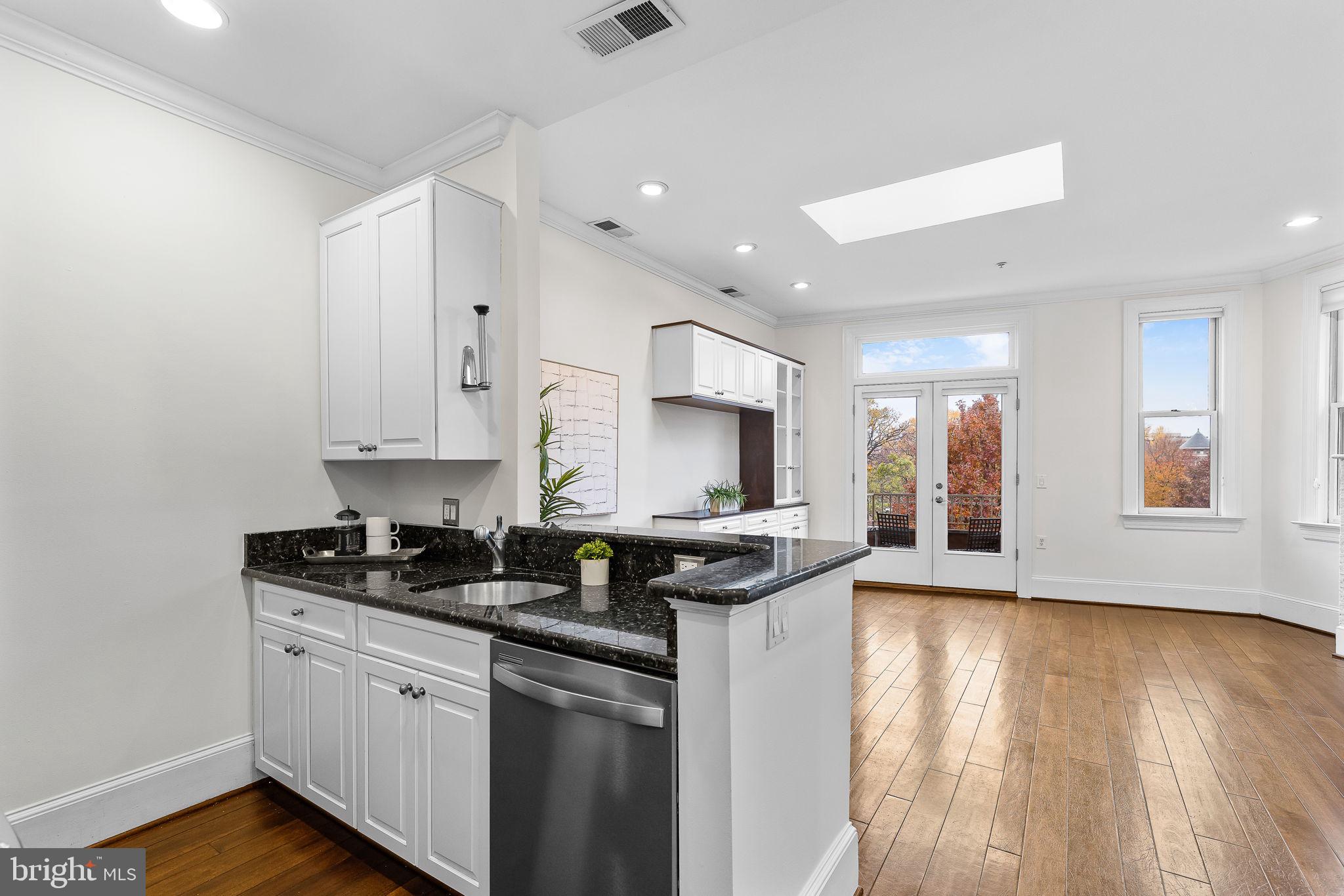 20 Logan Circle Northwest, Unit 33 Washington, DC 20005 - Photo 15 of 32 a kitchen with stainless steel appliances granite countertop a stove a sink and a microwave
