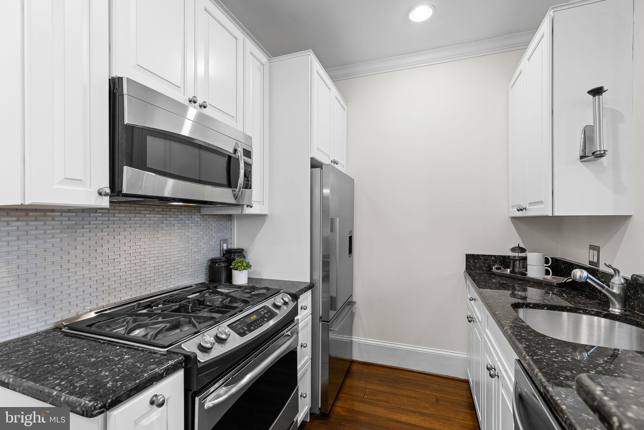 20 Logan Circle Northwest, Unit 33 Washington, DC 20005 - Photo 16 of 32 a kitchen with stainless steel appliances granite countertop a stove and a microwave