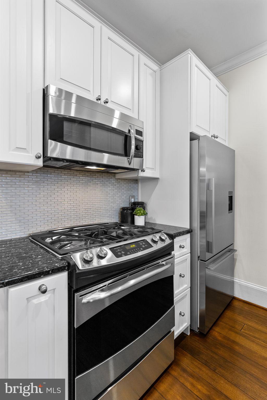 20 Logan Circle Northwest, Unit 33 Washington, DC 20005 - Photo 17 of 32 a kitchen with stainless steel appliances granite countertop a stove and a refrigerator