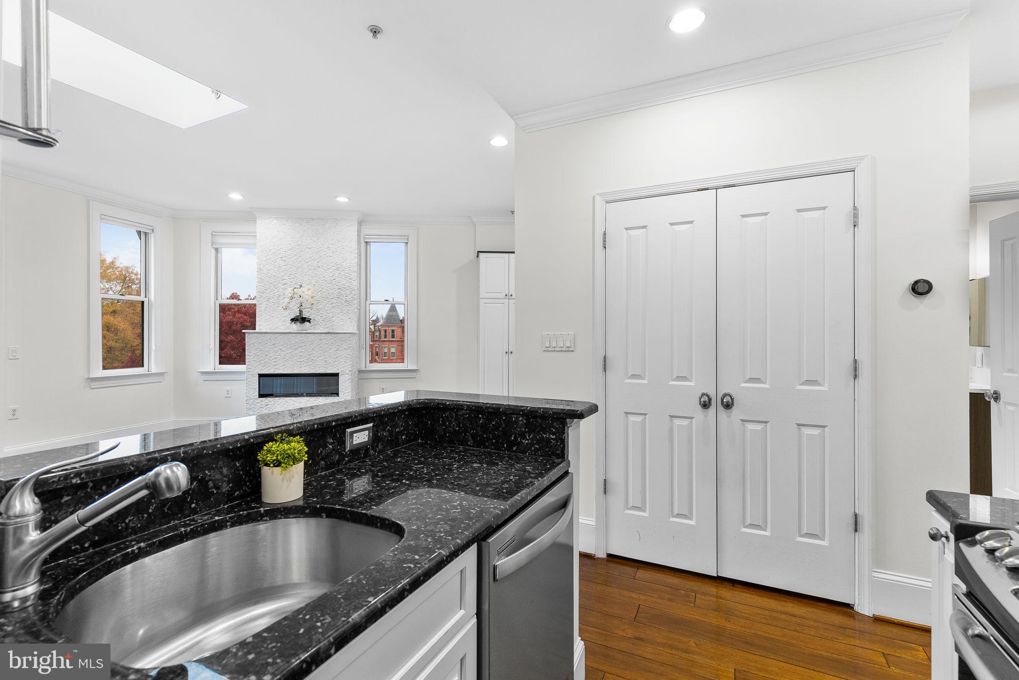 20 Logan Circle Northwest, Unit 33 Washington, DC 20005 - Photo 18 of 32 a kitchen with granite countertop a sink a stove and cabinets