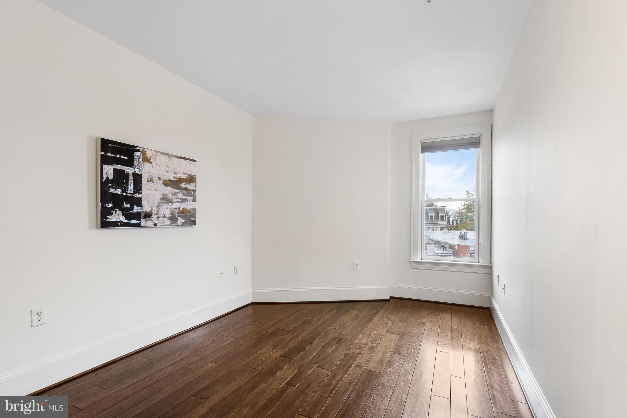20 Logan Circle Northwest, Unit 33 Washington, DC 20005 - Photo 24 of 32 an empty room with wooden floor and windows