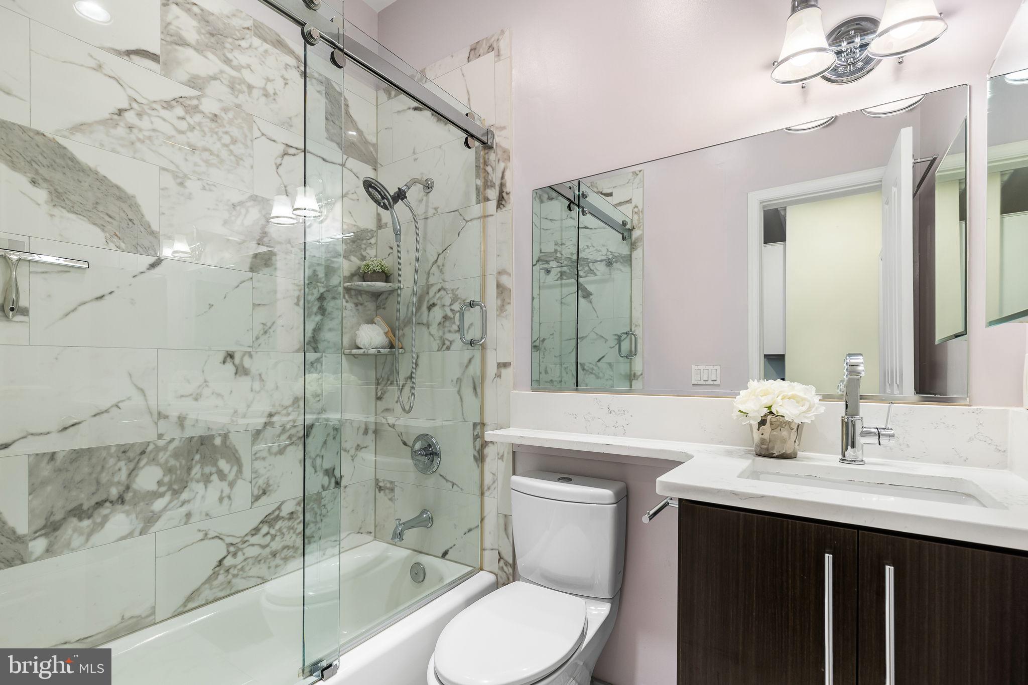 20 Logan Circle Northwest, Unit 33 Washington, DC 20005 - Photo 26 of 32 a bathroom with a sink toilet a mirror and shower