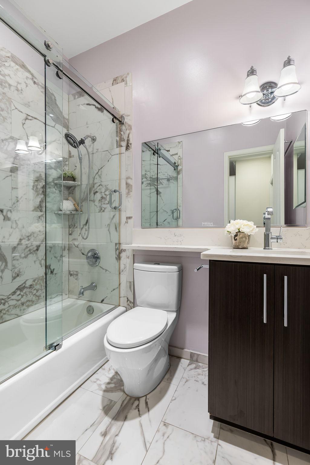 20 Logan Circle Northwest, Unit 33 Washington, DC 20005 - Photo 27 of 32 a bathroom with a sink toilet a mirror and shower