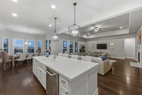 a large kitchen with kitchen island white cabinets and stainless steel appliances