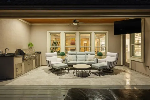 a living room with patio furniture and a wooden floor