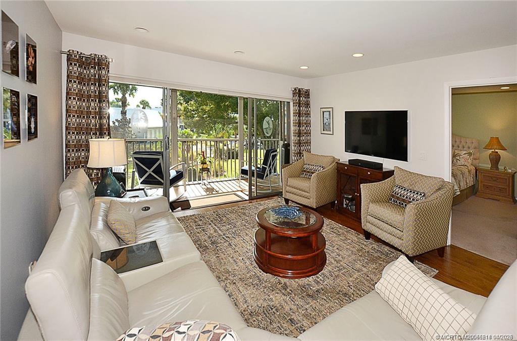1854 Southwest Palm City Road, Unit 203 Stuart, FL 34994 - Photo 11 of 38 The bright, open living room offers plenty of space to relax or entertain, with sliding glass doors that seamlessly connect to the screened lanai and bring in beautiful natural light.