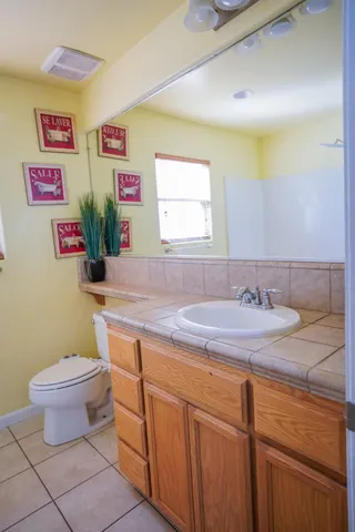 a bathroom with a granite countertop toilet sink and mirror