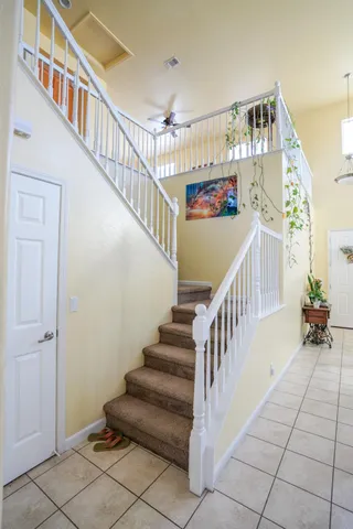 a view of staircase with lots of frames on wall and a chandelier