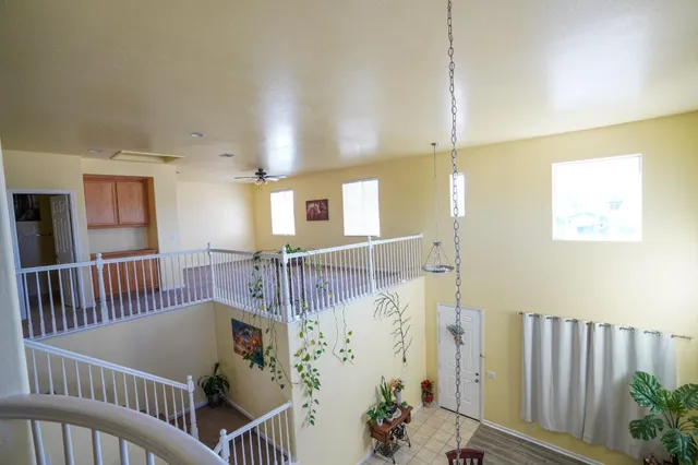 a view of a hallway with wooden floor and windows