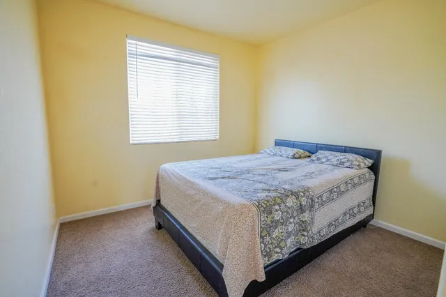 a bed sitting in a bedroom next to a window
