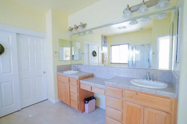 a en suite bathroom with a granite countertop sink and a mirror