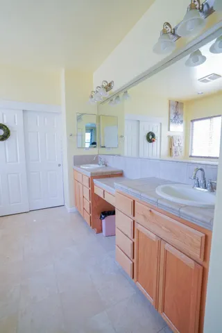 a spacious bathroom with a granite countertop sink and a mirror