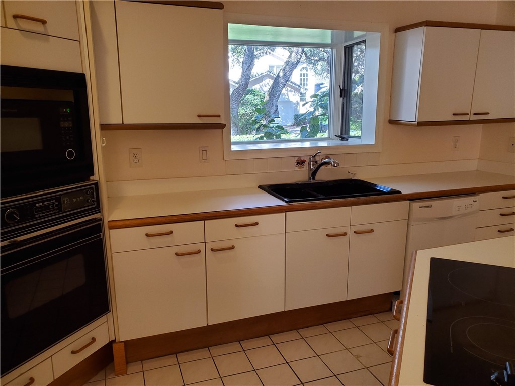 131 Peppertree Drive, Unit 21 Vero Beach, FL 32963 - Photo 11 of 25 a kitchen with a sink and cabinets