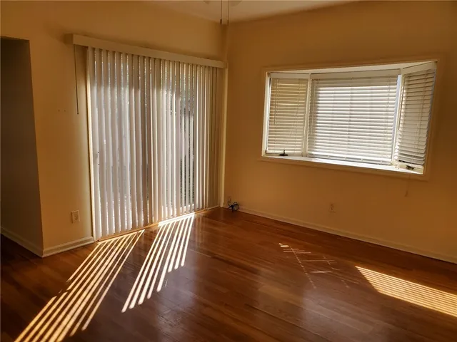 a view of a room with wooden floor and a window