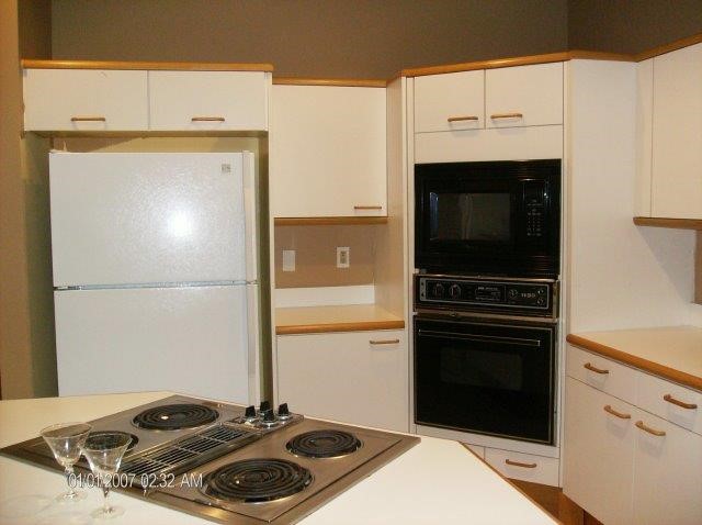 131 Peppertree Drive, Unit 21 Vero Beach, FL 32963 - Photo 17 of 25 a kitchen with a stove and a microwave