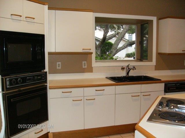 131 Peppertree Drive, Unit 21 Vero Beach, FL 32963 - Photo 18 of 25 a kitchen with a sink stove and microwave
