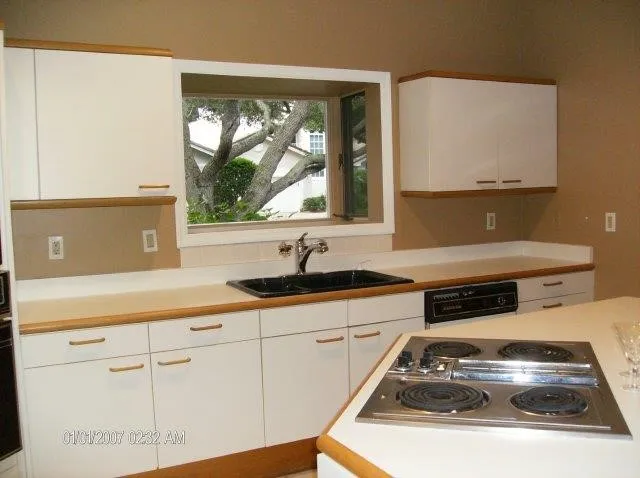 a kitchen with white cabinets and a stove top oven