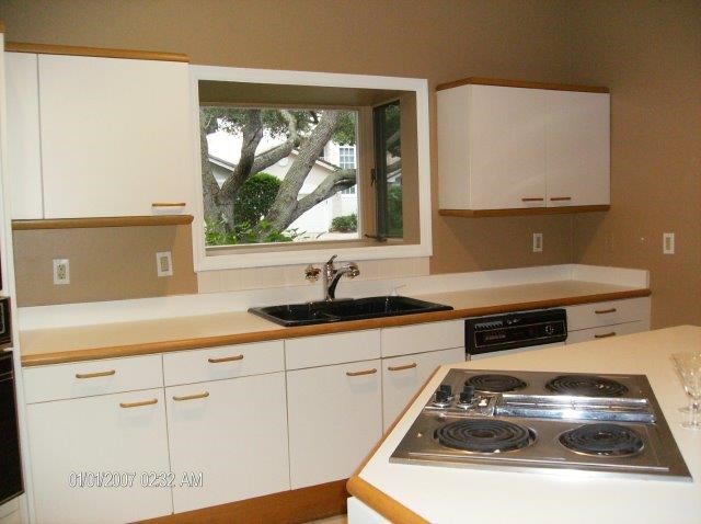 131 Peppertree Drive, Unit 21 Vero Beach, FL 32963 - Photo 19 of 25 a kitchen with white cabinets and a stove top oven