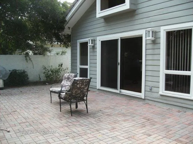 a patio with table and chairs and potted plants