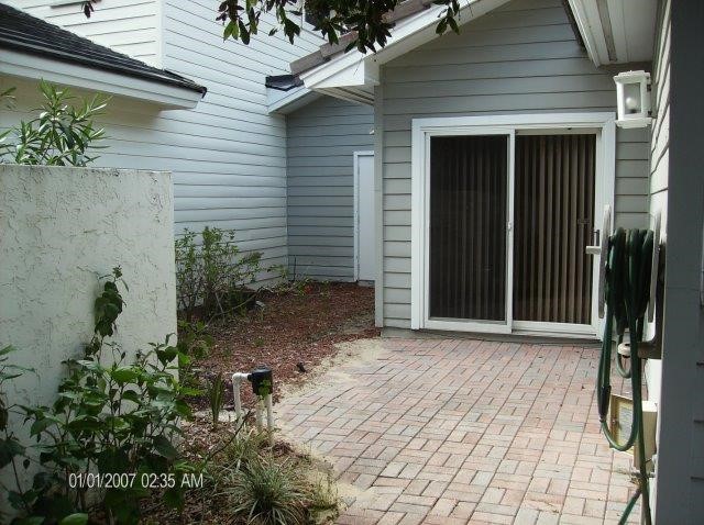 131 Peppertree Drive, Unit 21 Vero Beach, FL 32963 - Photo 23 of 25 a backyard of a house with potted plants and a bench