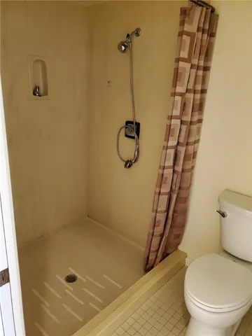 a bathroom with a granite countertop toilet and a shower