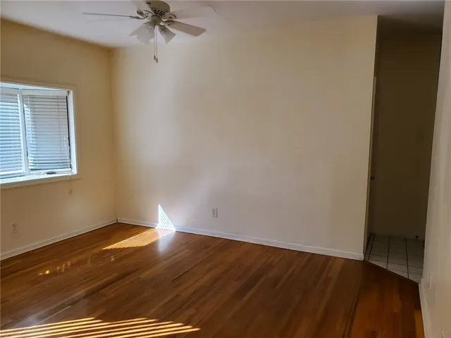 a view of a room with wooden floor and a ceiling fan