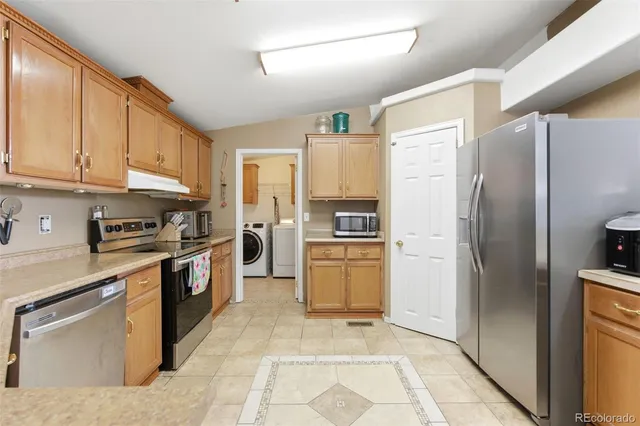 a kitchen with a refrigerator sink and stainless steel appliances