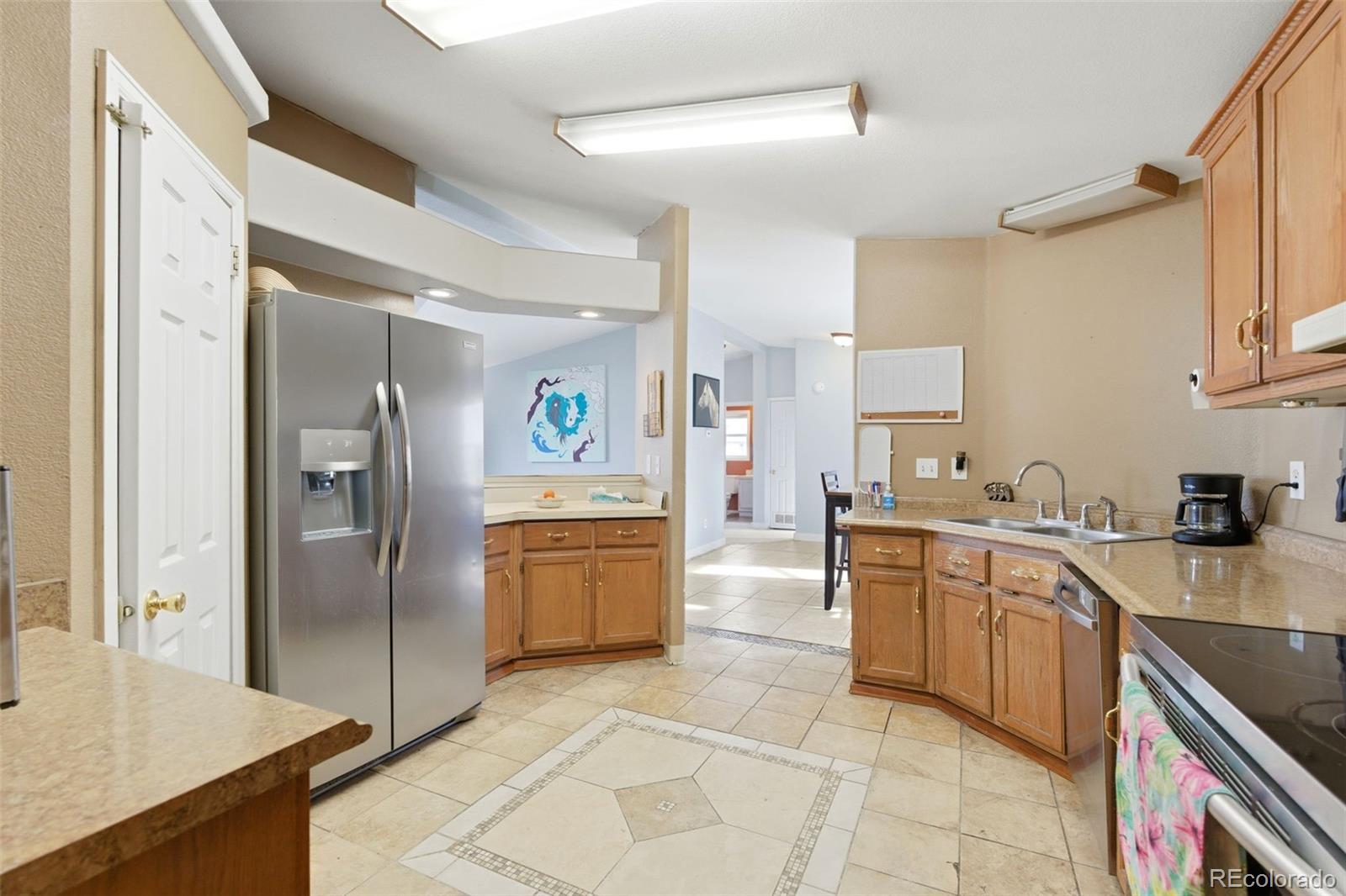 8137 Lafayette Street Denver, CO 80229 - Photo 15 of 36 a kitchen with stainless steel appliances granite countertop a sink stove and refrigerator