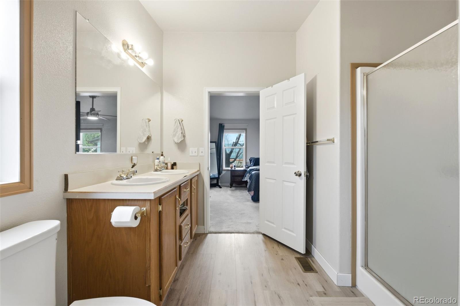 8137 Lafayette Street Denver, CO 80229 - Photo 20 of 36 a en suite bathroom with a sink mirror and toilet