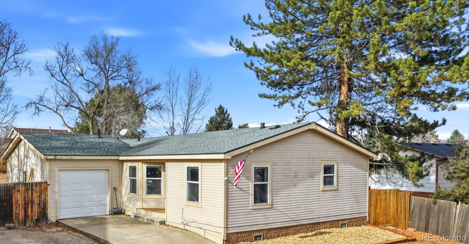8137 Lafayette Street Denver, CO 80229 - Photo 2 of 36 a view of a white house with a tree and wooden fence