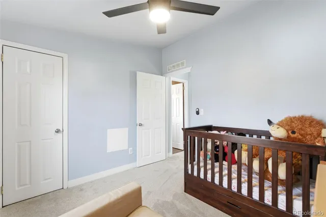 a bedroom with furniture and a chandelier fan