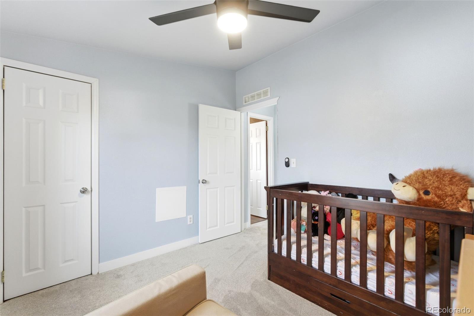 8137 Lafayette Street Denver, CO 80229 - Photo 26 of 36 a bedroom with furniture and a chandelier fan
