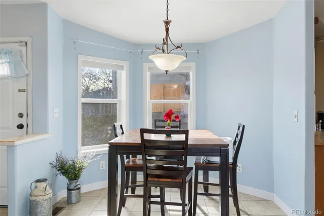 a dining room with furniture potted plants and a chandelier