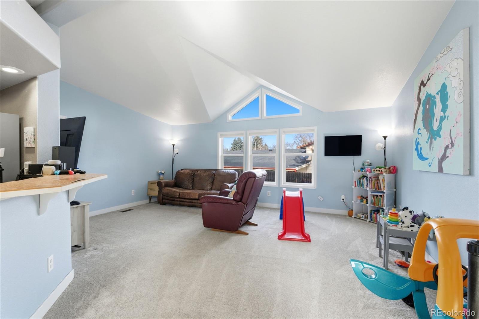 8137 Lafayette Street Denver, CO 80229 - Photo 7 of 36 a living room with furniture and a flat screen tv