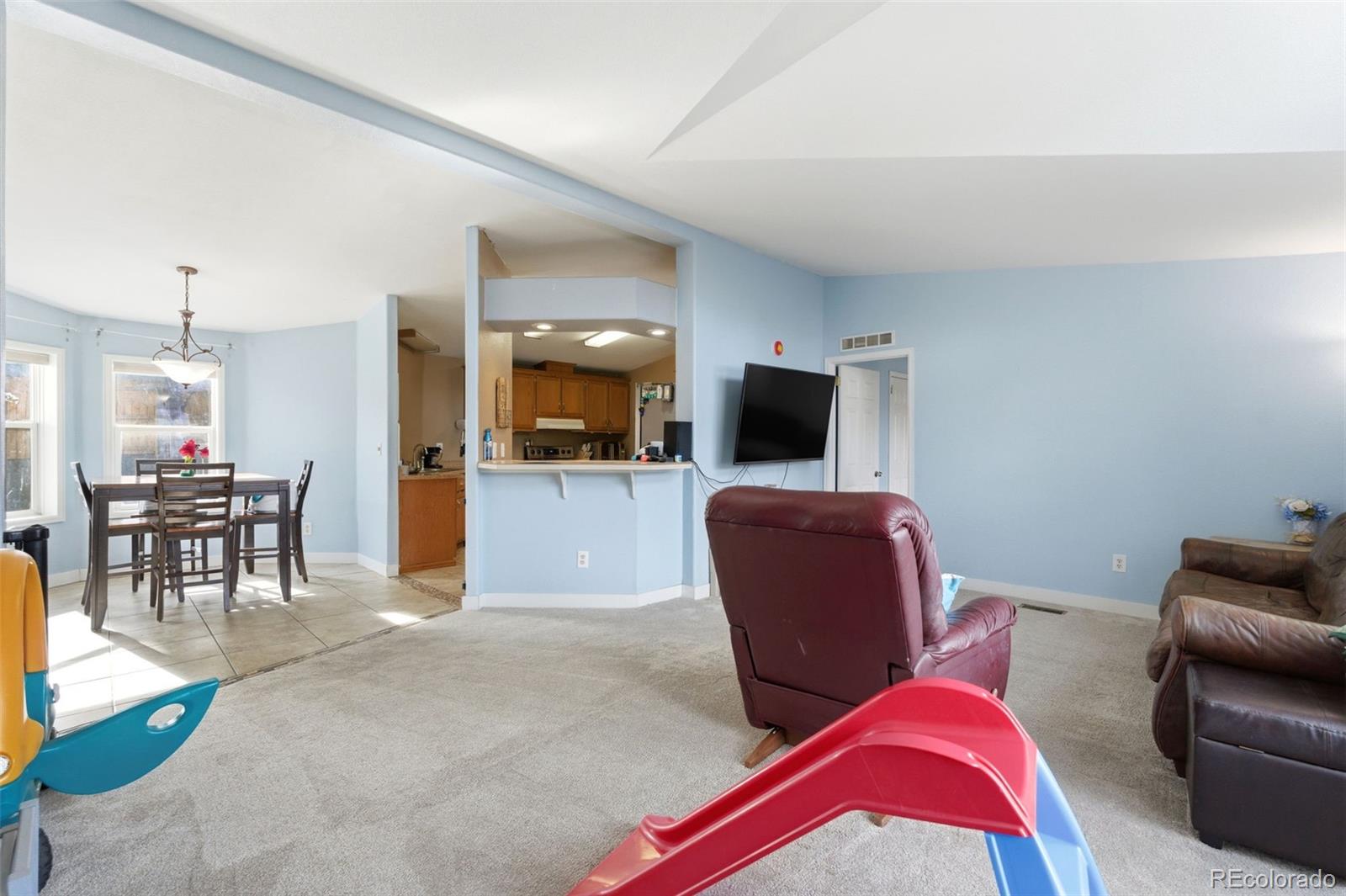 8137 Lafayette Street Denver, CO 80229 - Photo 9 of 36 a living room with furniture and a flat screen tv