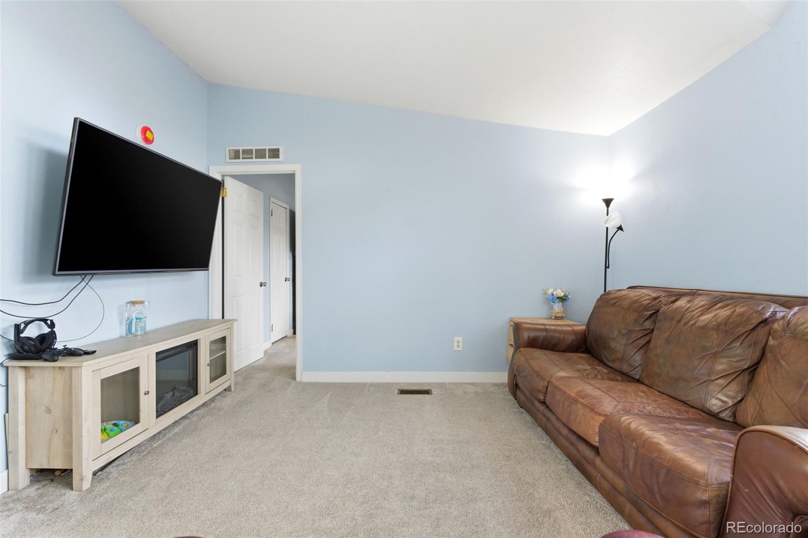 8137 Lafayette Street Denver, CO 80229 - Photo 10 of 36 a living room with furniture and a flat screen tv